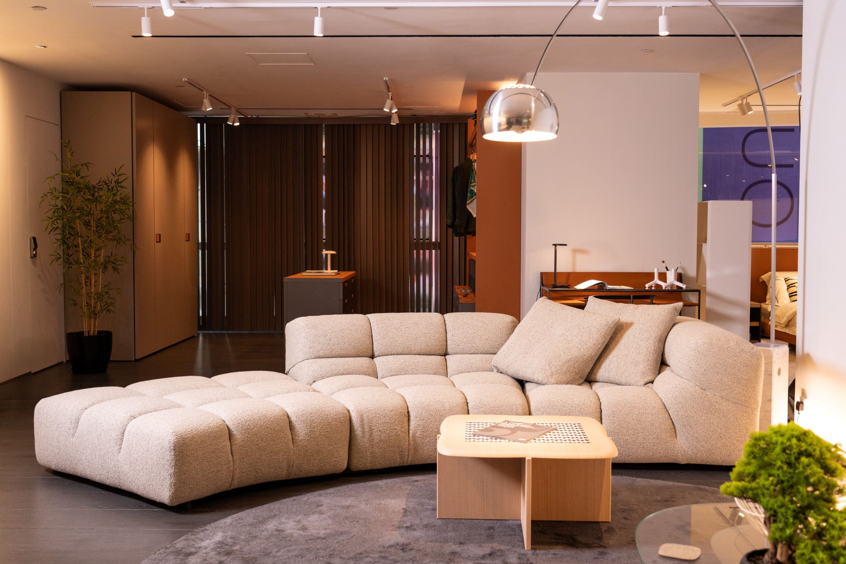 Modern living room with a large beige sectional sofa and a wooden coffee table.