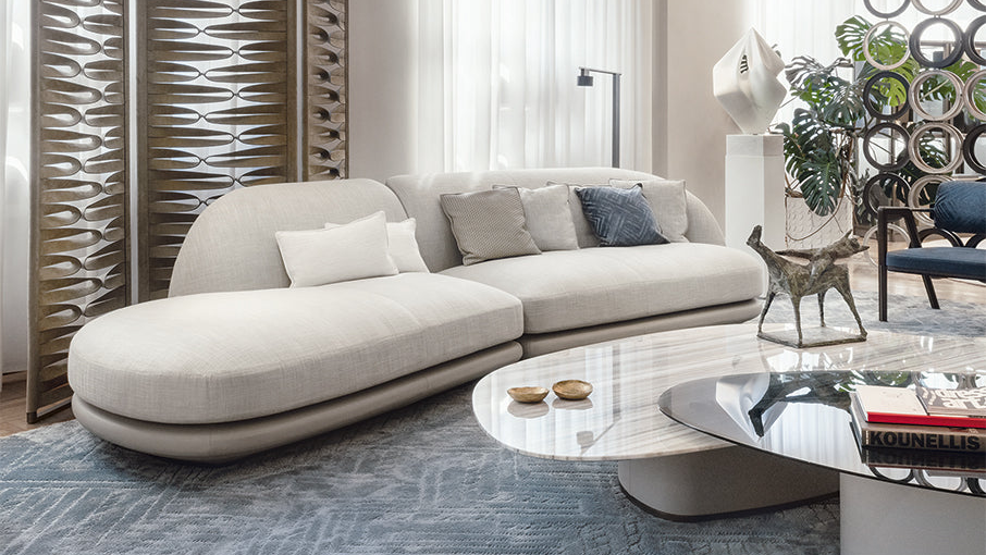 Modern living room with a beige sectional sofa, coffee table, and decorative elements.