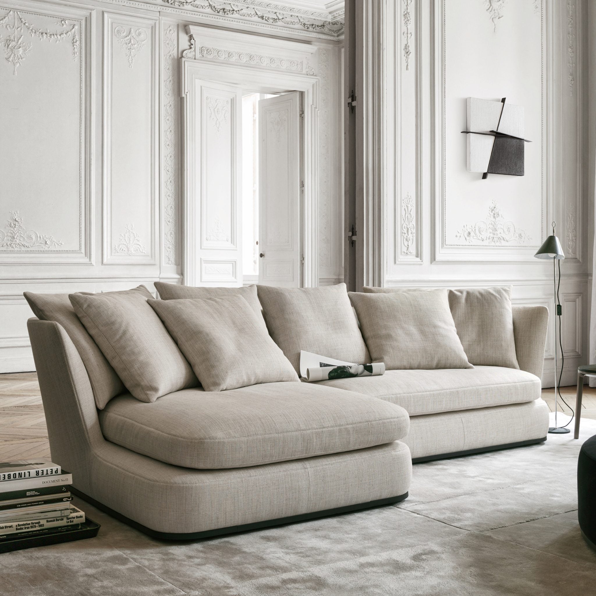 Beige sofa in a stylish living room with decorative walls and a lamp.