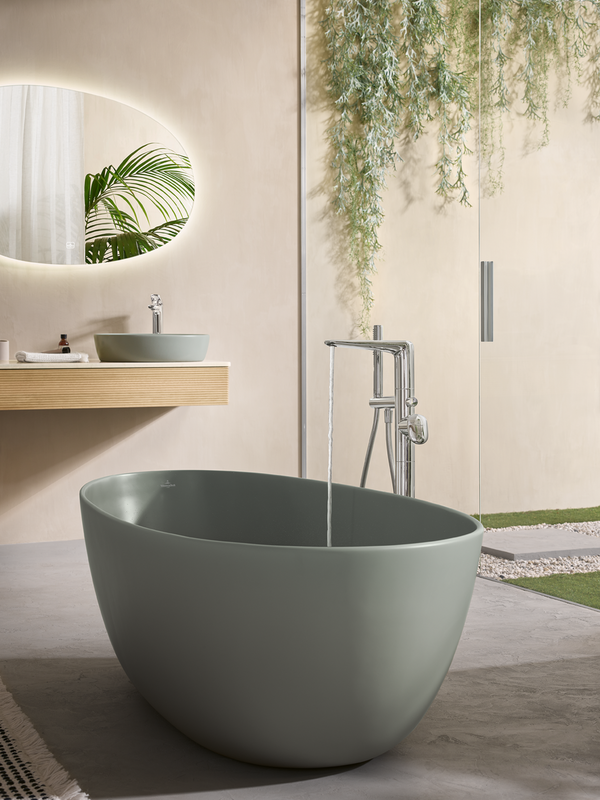 Modern bathroom with a freestanding bathtub, sink, and decorative mirror.